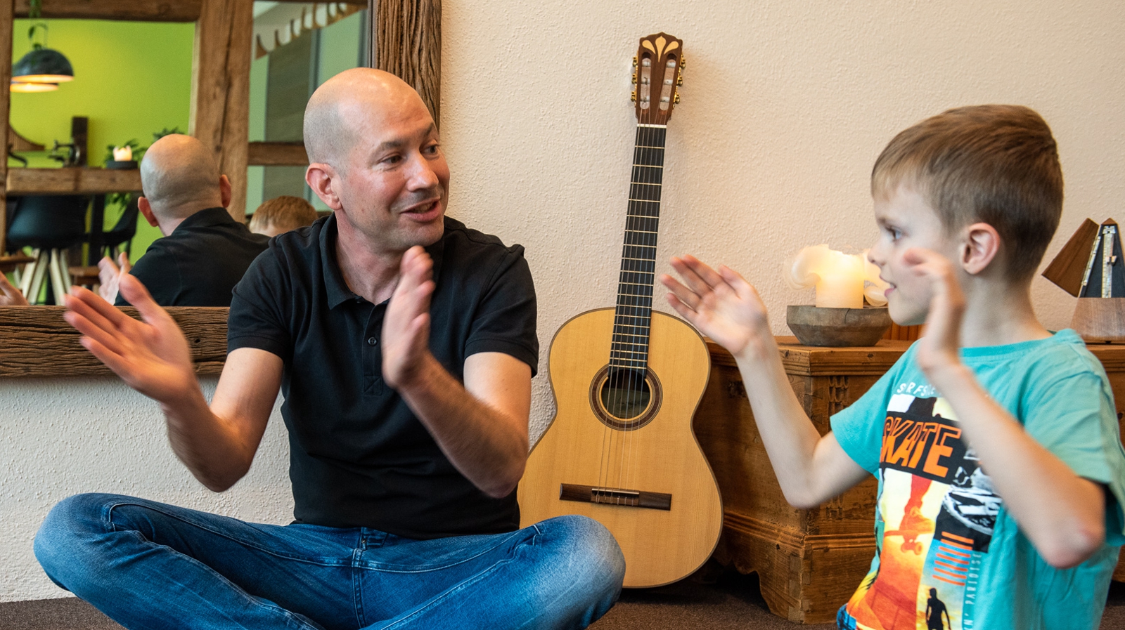 Musikpädagoge mit Kind am klatschen während Musikunterricht